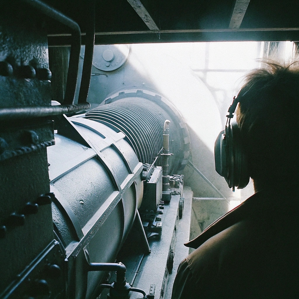 Technician inspecting a large industrial engine, ensuring generator efficiency and safety