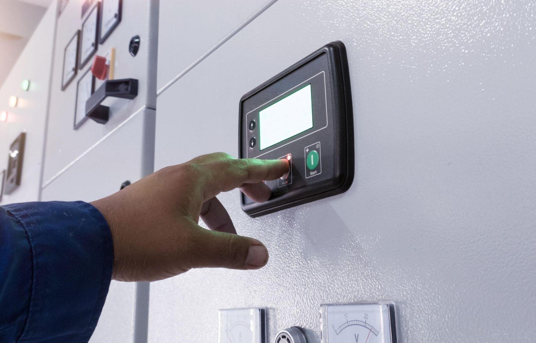 technician diagnosing diesel generator voltage and frequency under load